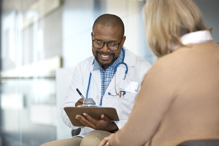 Photo shows doctor talking with patient in hospital/Getty Images