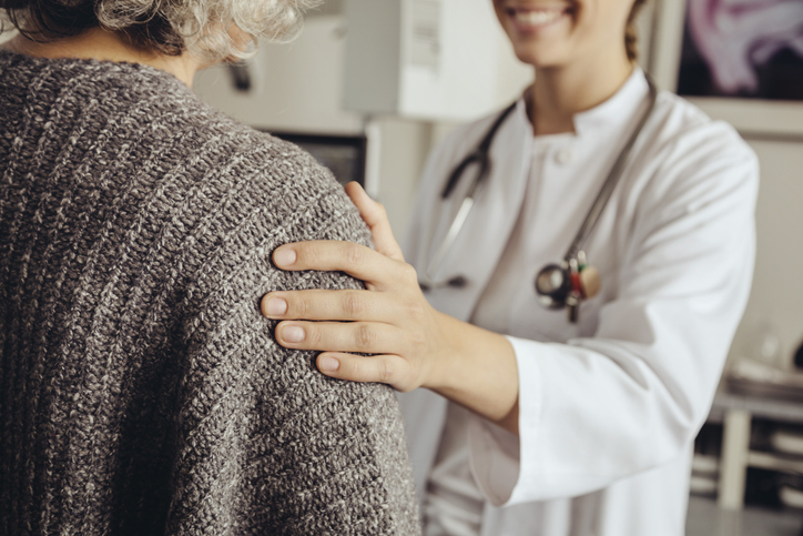 Photo shows doctor talking to senior patient/Getty Images
