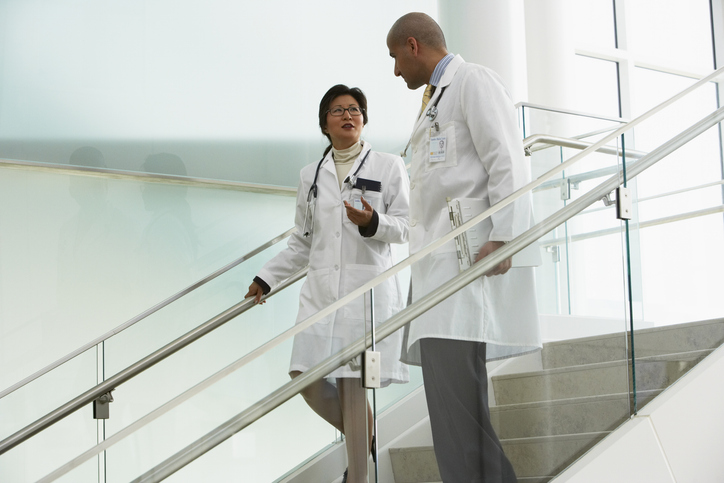 Photo shows two doctors walking on steps, talking/Getty images