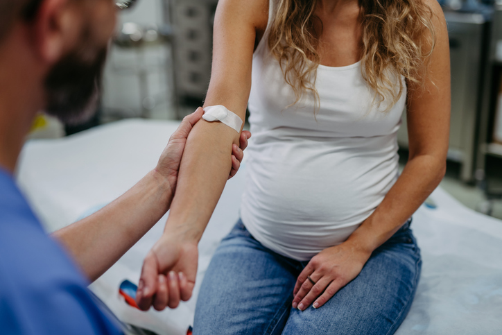 Obstetrician gynaecologist taking blood sample from pregnant woman as a part of prenatal care, visit. Pregnant woman on pregnancy check-up in doctor’s office. Gestational diabetes test. Anemia test, iron deficiency, Rh factor and serological tests in pregnant woman.