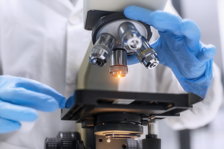 Photo shows a zoomed in view of a scientist using a microscope/Getty Images