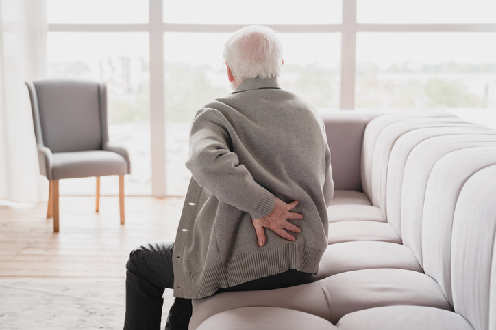 Photo shows older man with back pain