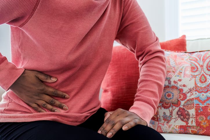 Photo shows woman with abdominal pain