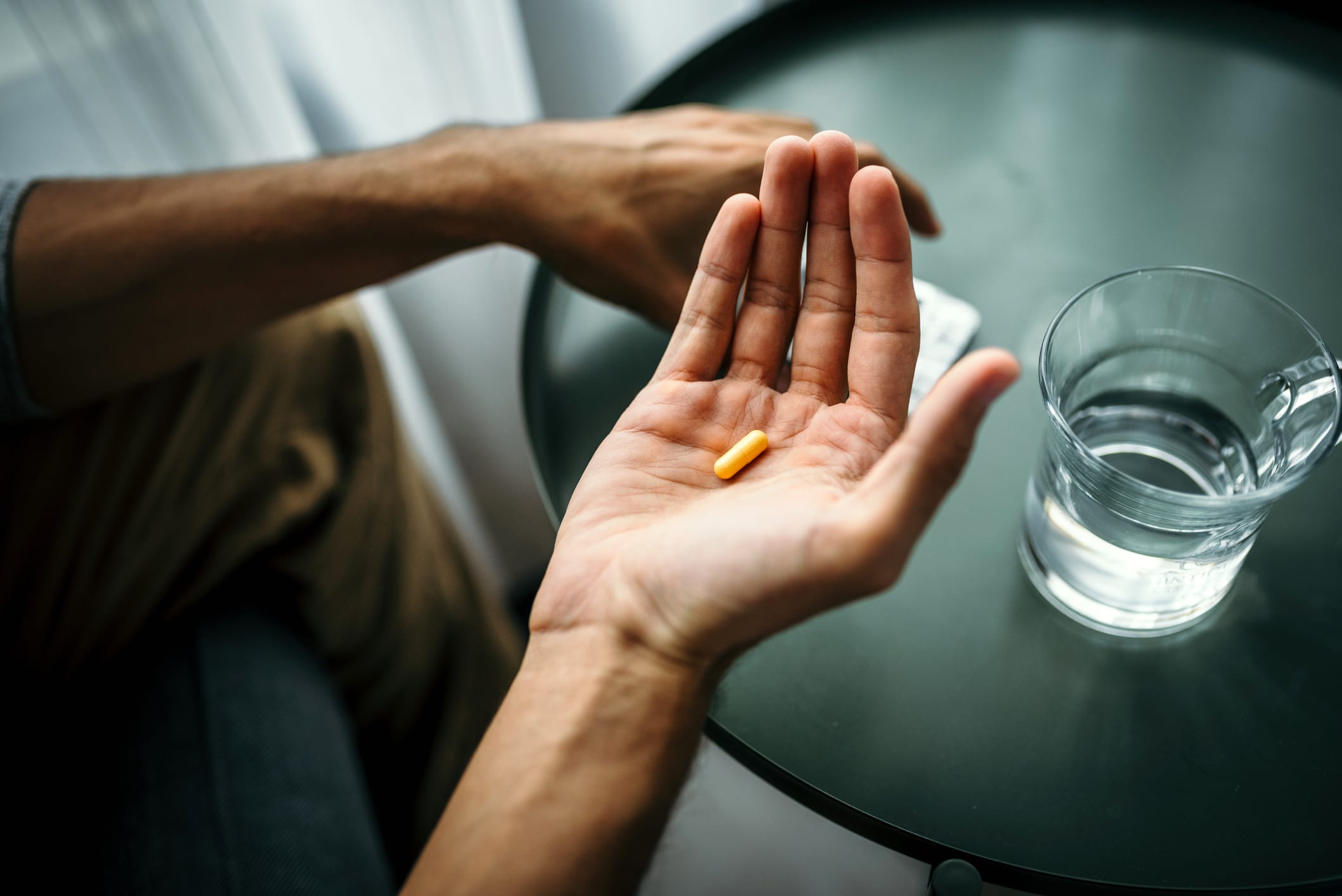 Photo of man's hand holding a pill