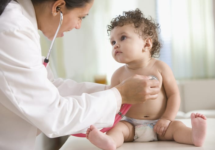 Photo shows doctor examining baby