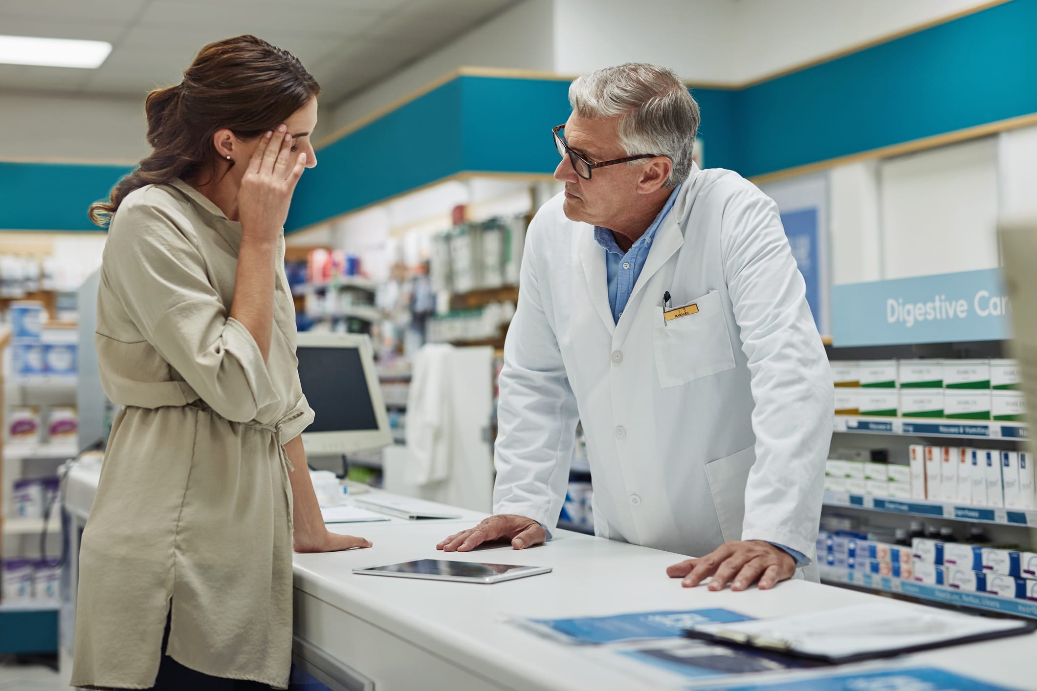 Shot of a mature pharmacist helping a customer at the counter in a chemist