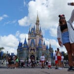 A woman takes a selfie before Cinderella's Castle at the Magic Kingdom Park at Walt Disney World