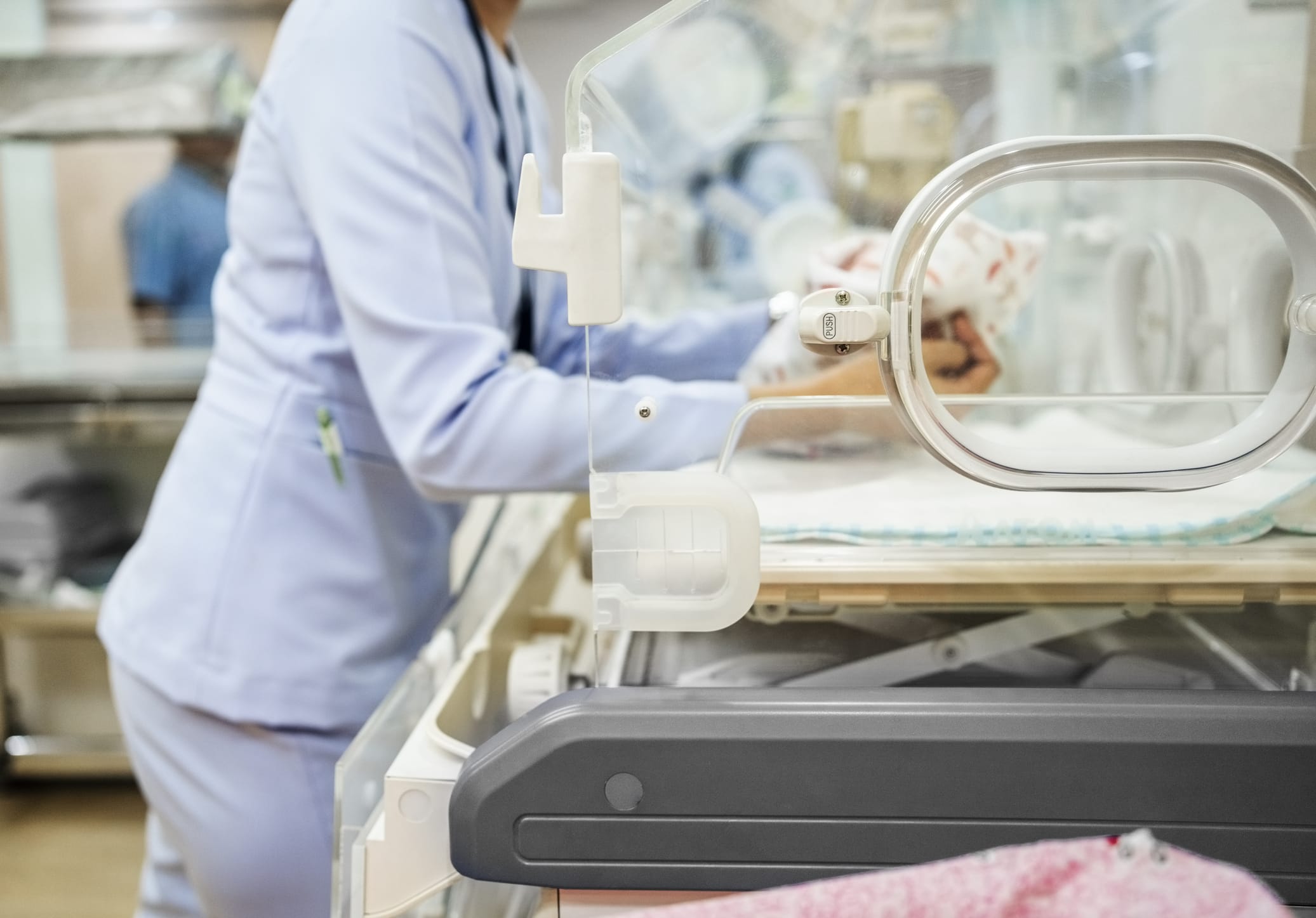 Cropped shot of pediatrician nurse keeping a newborn baby inside incubator at NICU