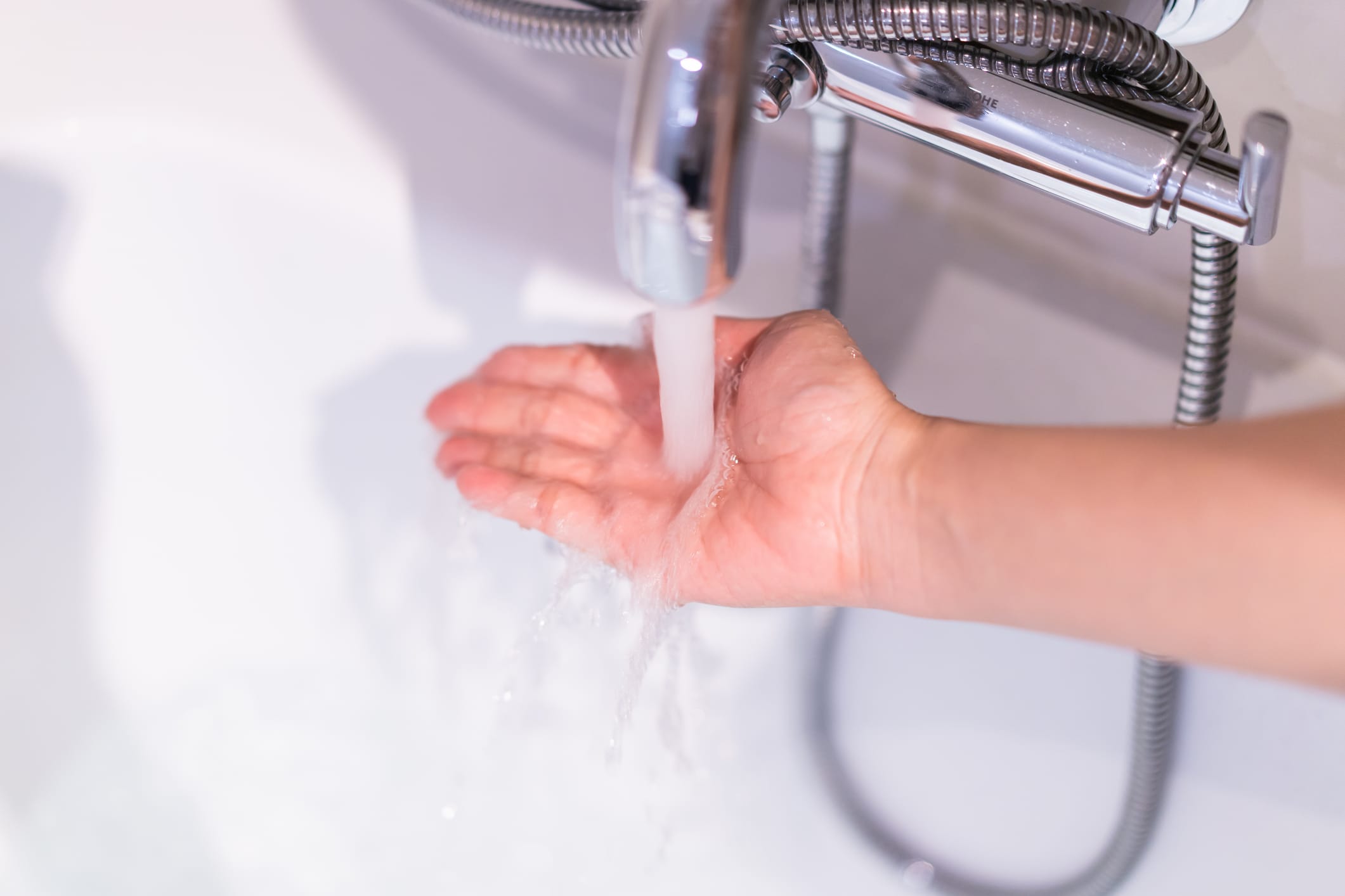 Hand testing the water in a tub