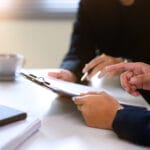 People reviewing paperwork before signing