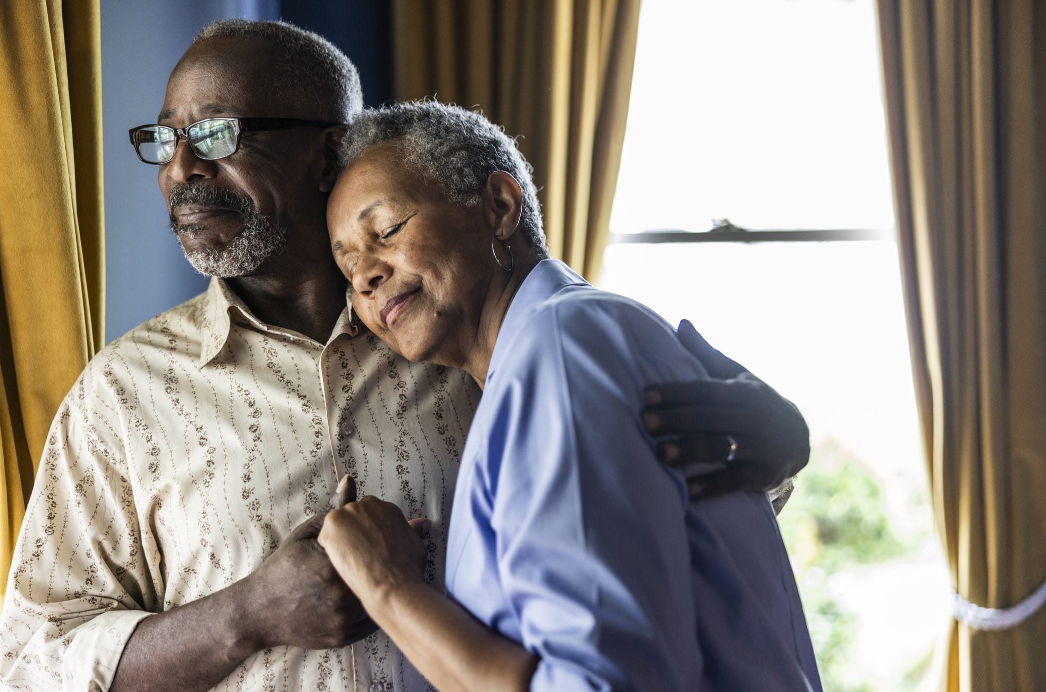 Older couple standing in front of a window