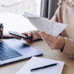 Woman sitting in front of laptop paying bills