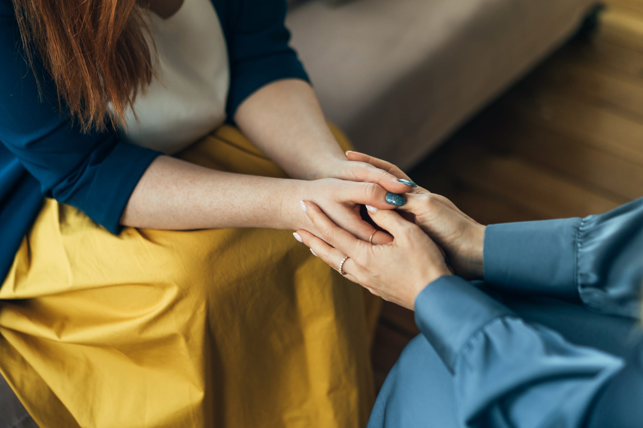 Two women holding hands while sitting