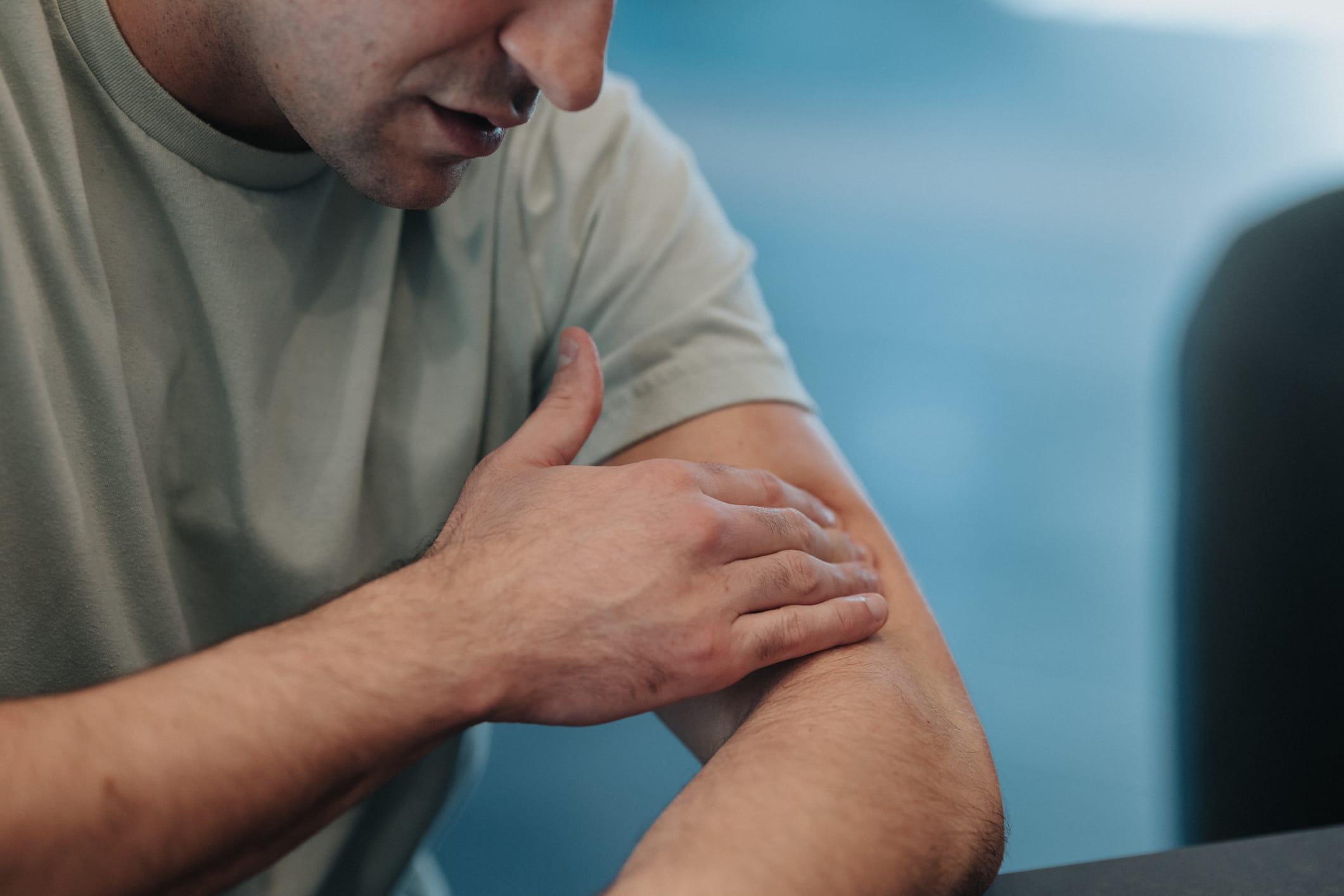 Man touching injured arm
