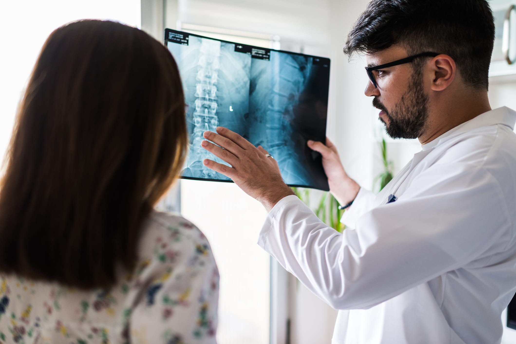 Healthcare professional looking at spine imaging with a patient