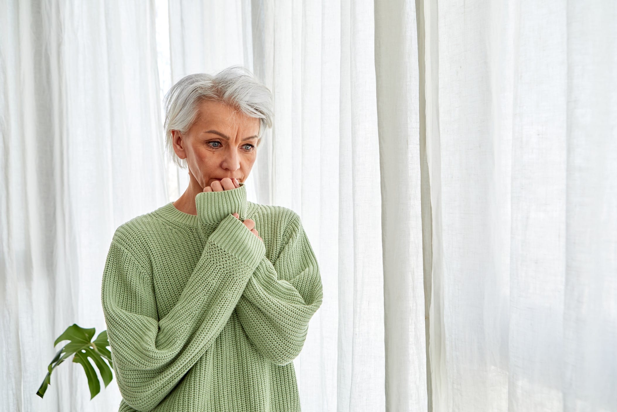 Worried older woman in a thick sweater