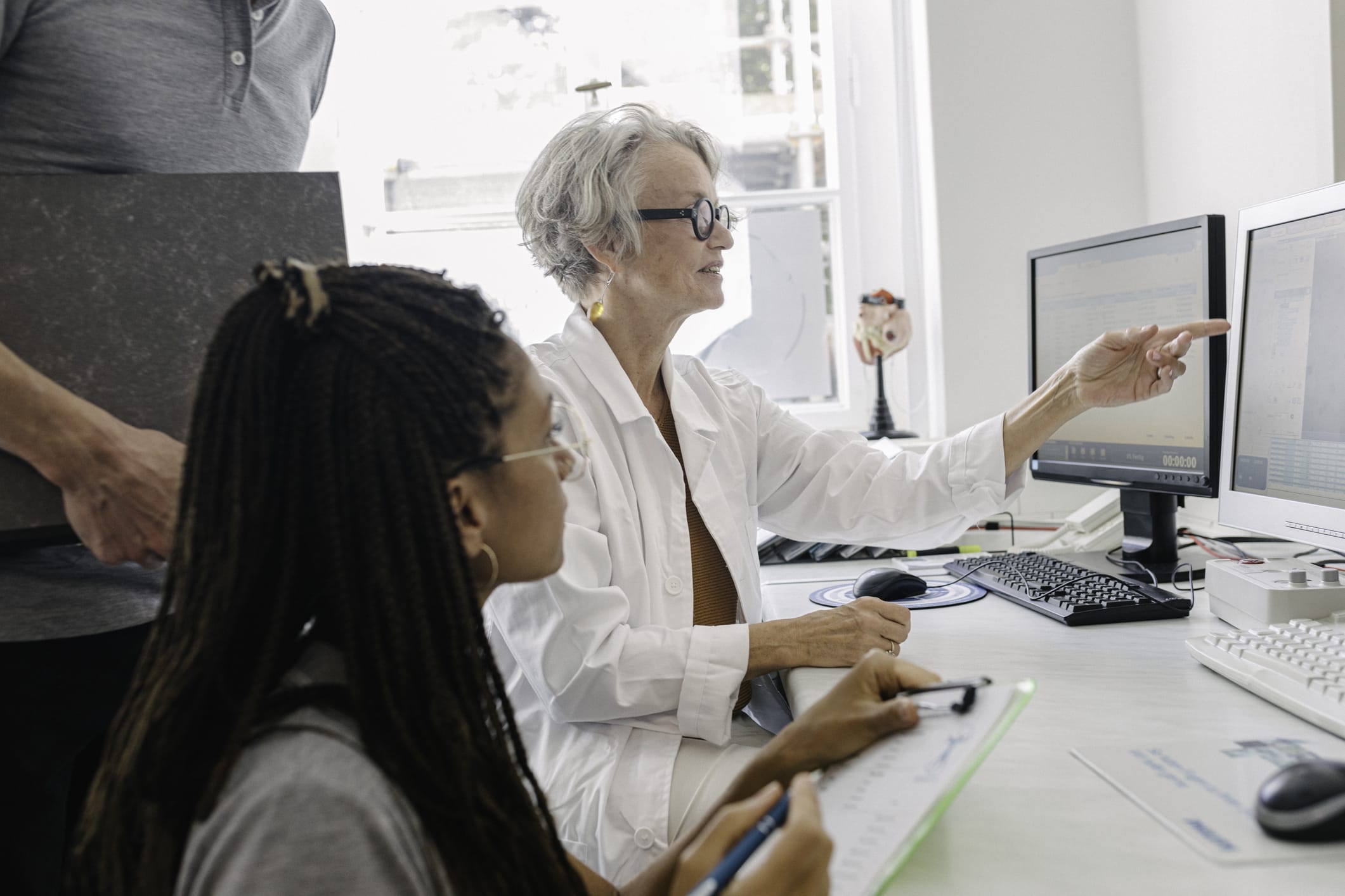 Doctors looking at data on computer monitor