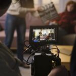 A camera operator films on set