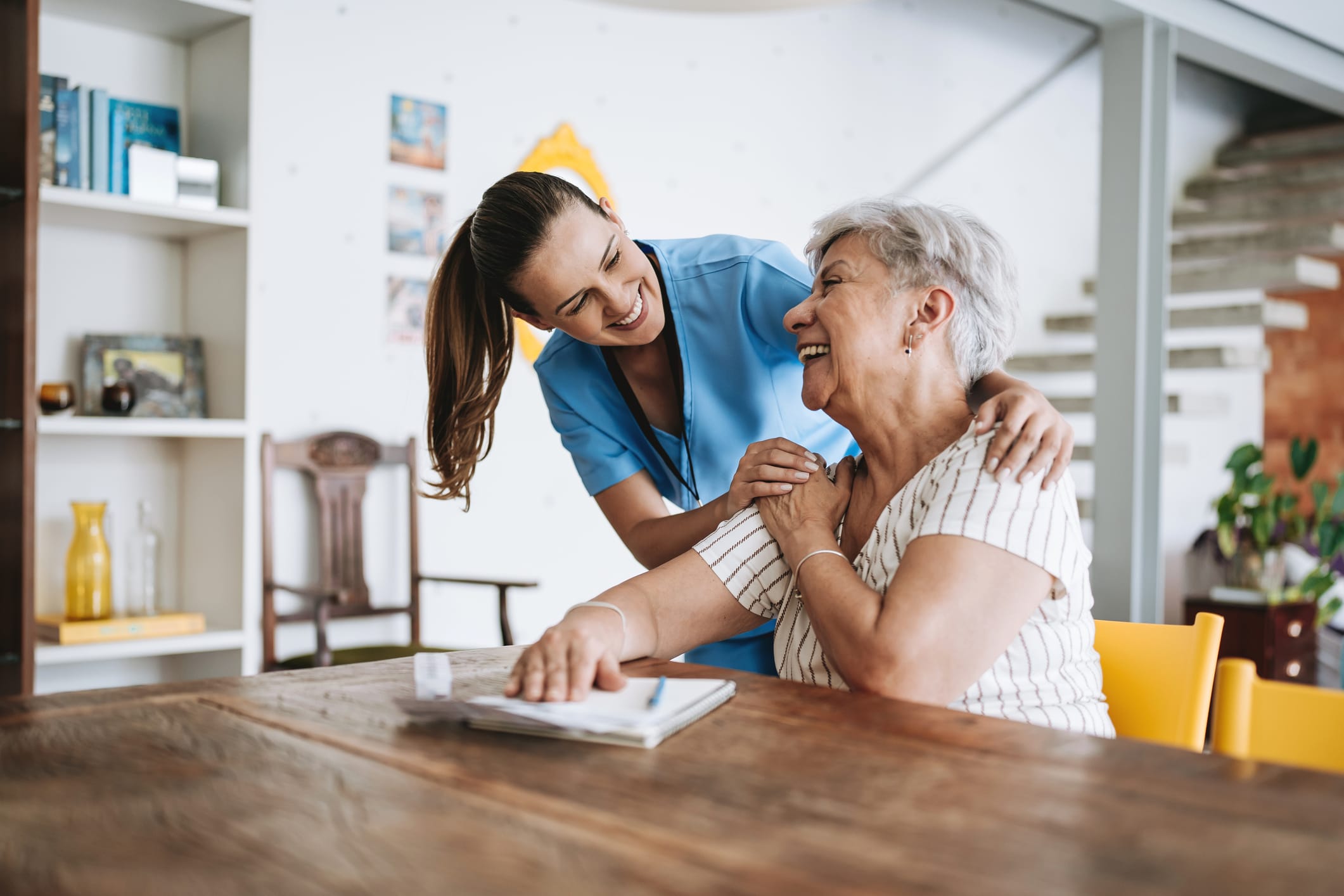 Home care healthcare professional hugging senior patient