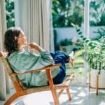 Woman relaxing in a chair surrounded by plants