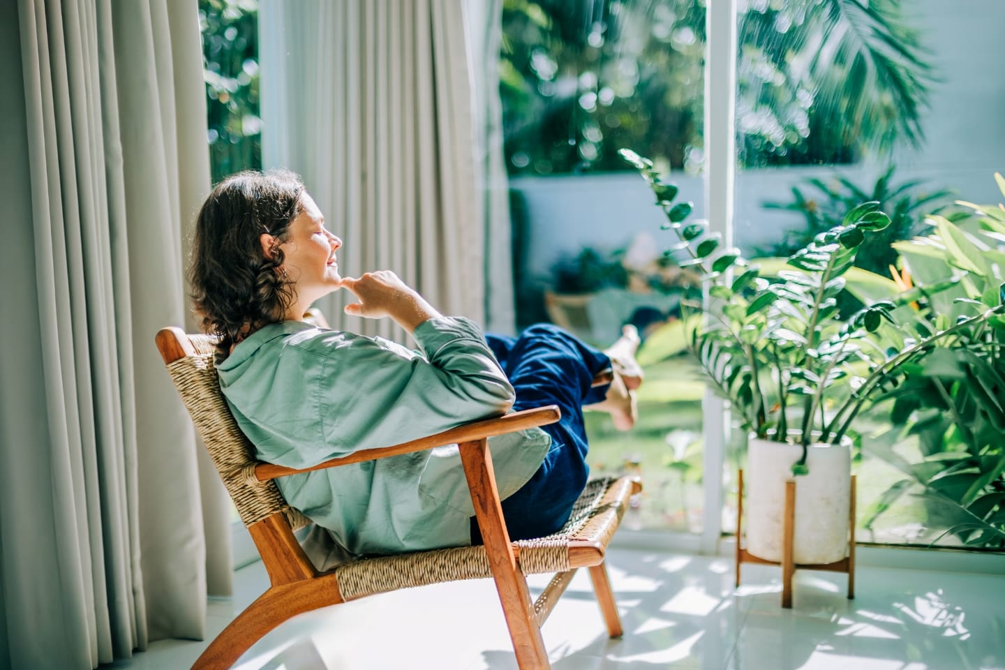 Woman relaxing in a chair surrounded by plants