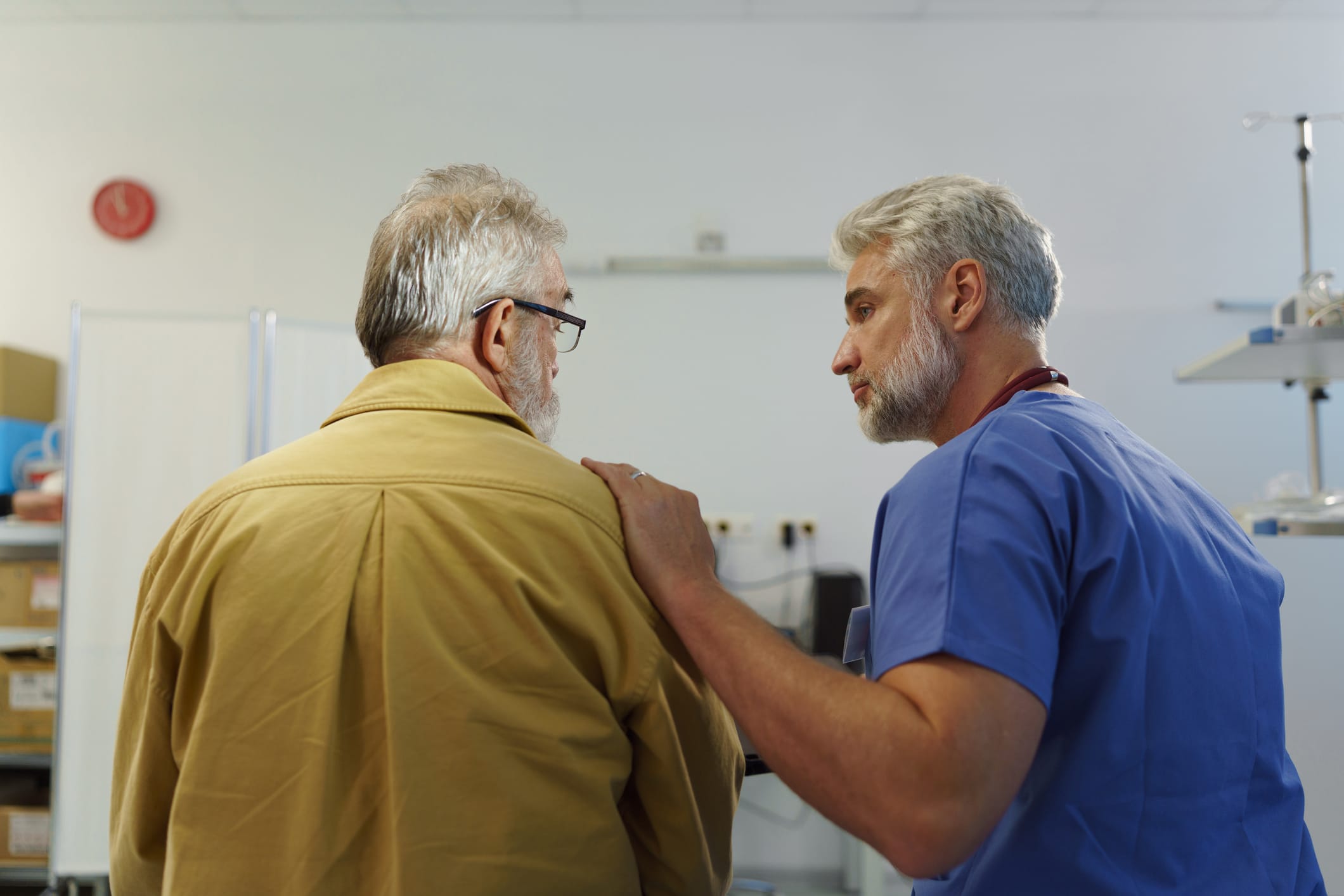 Doctor offering emotional support to older man.